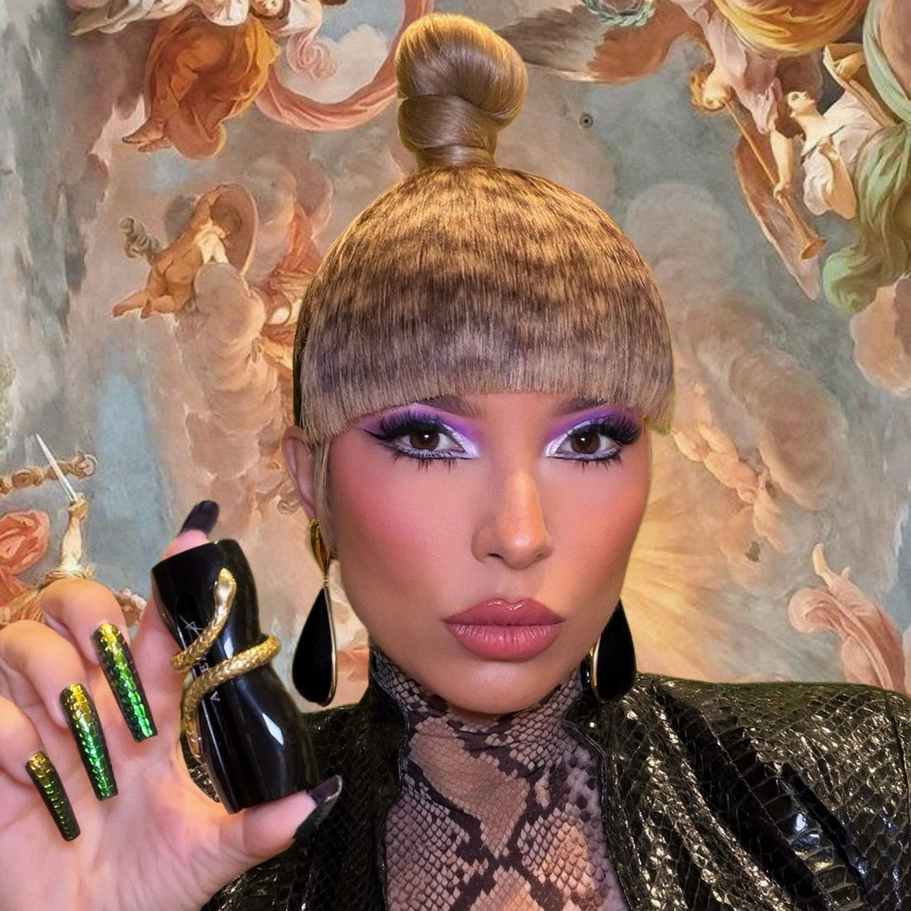Person holding a black lipstick with ornate wall art in the background